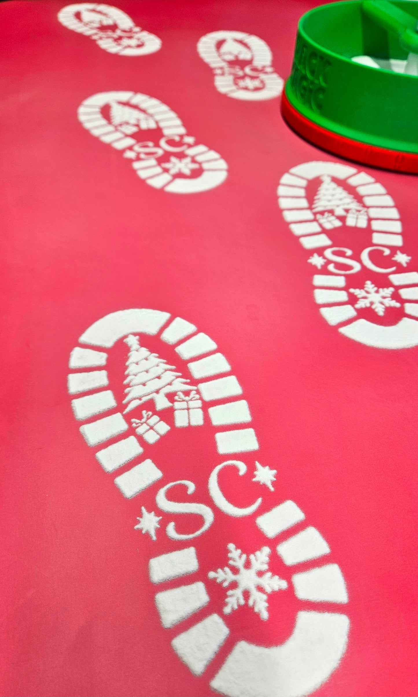 Red mat with white candy cane and snowflake designs on a red background